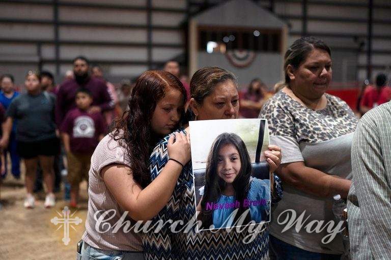 Esmeralda Bravo, center, holds a photo of her granddaughter, Nevaeh Bravo, one of the Robb Elementary School shooting victims, as she is comforted by Nevaeh