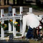 A woman kneels as she pays her respects in front of crosses with the names of children killed outside of the Robb Elementary School in Uvalde, Texas Thursday, May 26, 2022. Law enforcement authorities faced questions and criticism Thursday over how much time elapsed before they stormed the Texas elementary school classroom and put a stop to the rampage by a gunman who killed 19 children and two teachers. (AP Photo/Dario Lopez-Mills)
