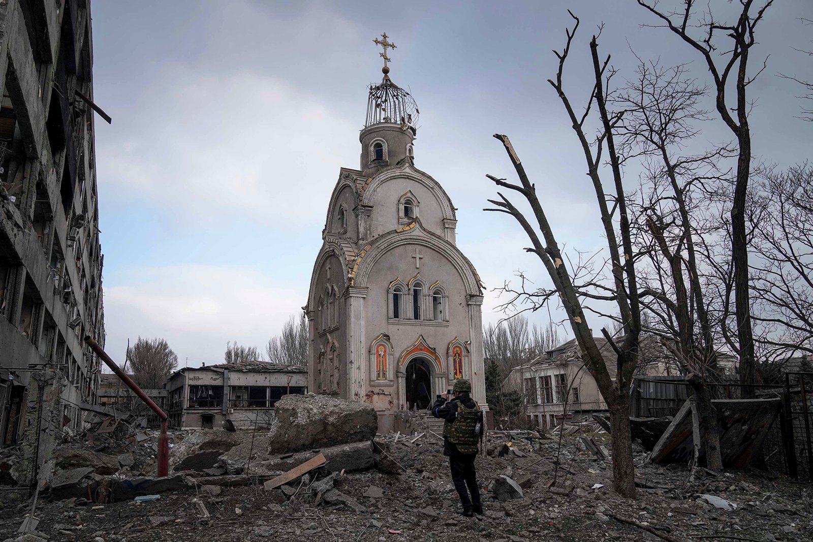 Un militar ucraniano toma una fotografía de una iglesia dañada después de un bombardeo en un distrito residencial en Mariúpol, Ucrania, Jueves, 10 de marzo de 2022. (Foto AP/Evgeniy Maloletka)