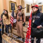 Jacob Chansley, center, better known as the “QAnon Shaman,” and other supporters of then-President Donald Trump are confronted by Capitol Police officers outside the Senate Chamber inside the Capitol, Jan. 6, 2021, in Washington. (AP Photo/Manuel Balce Ceneta)