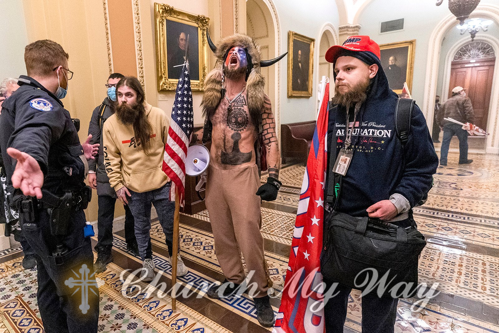 Jacob Chansley, center, better known as the “QAnon Shaman,” and other supporters of then-President Donald Trump are confronted by Capitol Police officers outside the Senate Chamber inside the Capitol, Jan. 6, 2021, in Washington. (AP Photo/Manuel Balce Ceneta)